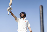 Cricket player holding his bat in the air