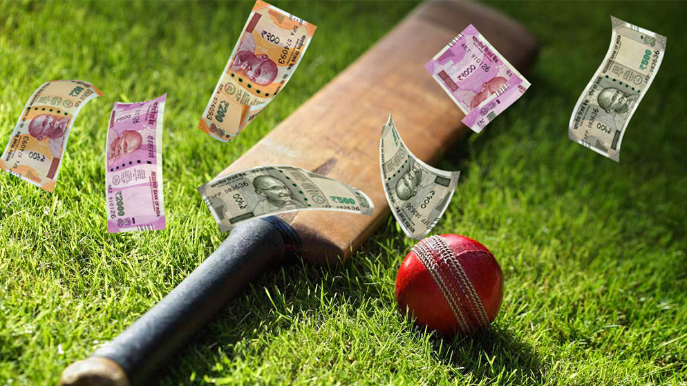 Cricket bat and ball lying on grass with Indian rupees falling down